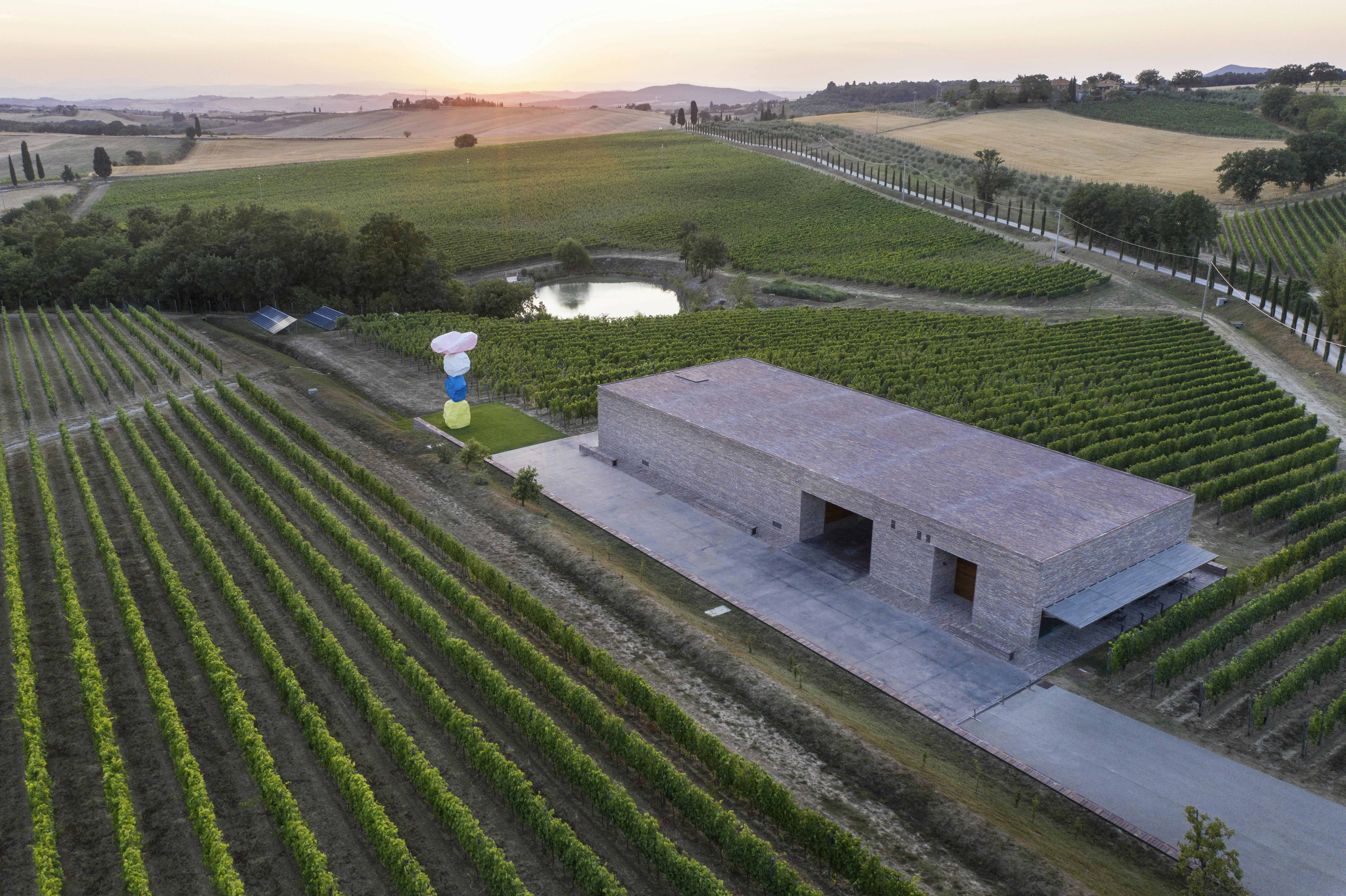 Aerial view by drone of the winery with the sculpture of Ugo Rondinone, lake, vineyards and Pienza